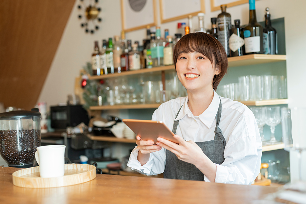 タブレットを触るカフェの店員